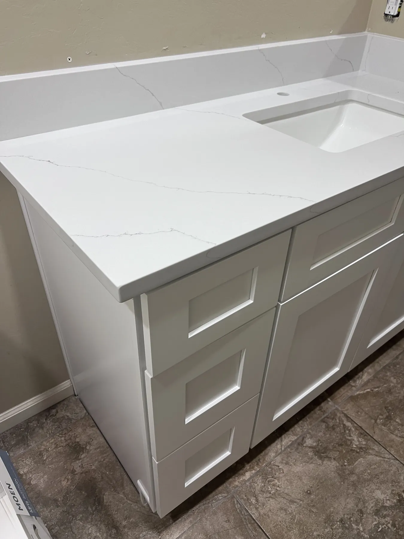 Completed compact bathroom vanity with white cabinetry and countertop