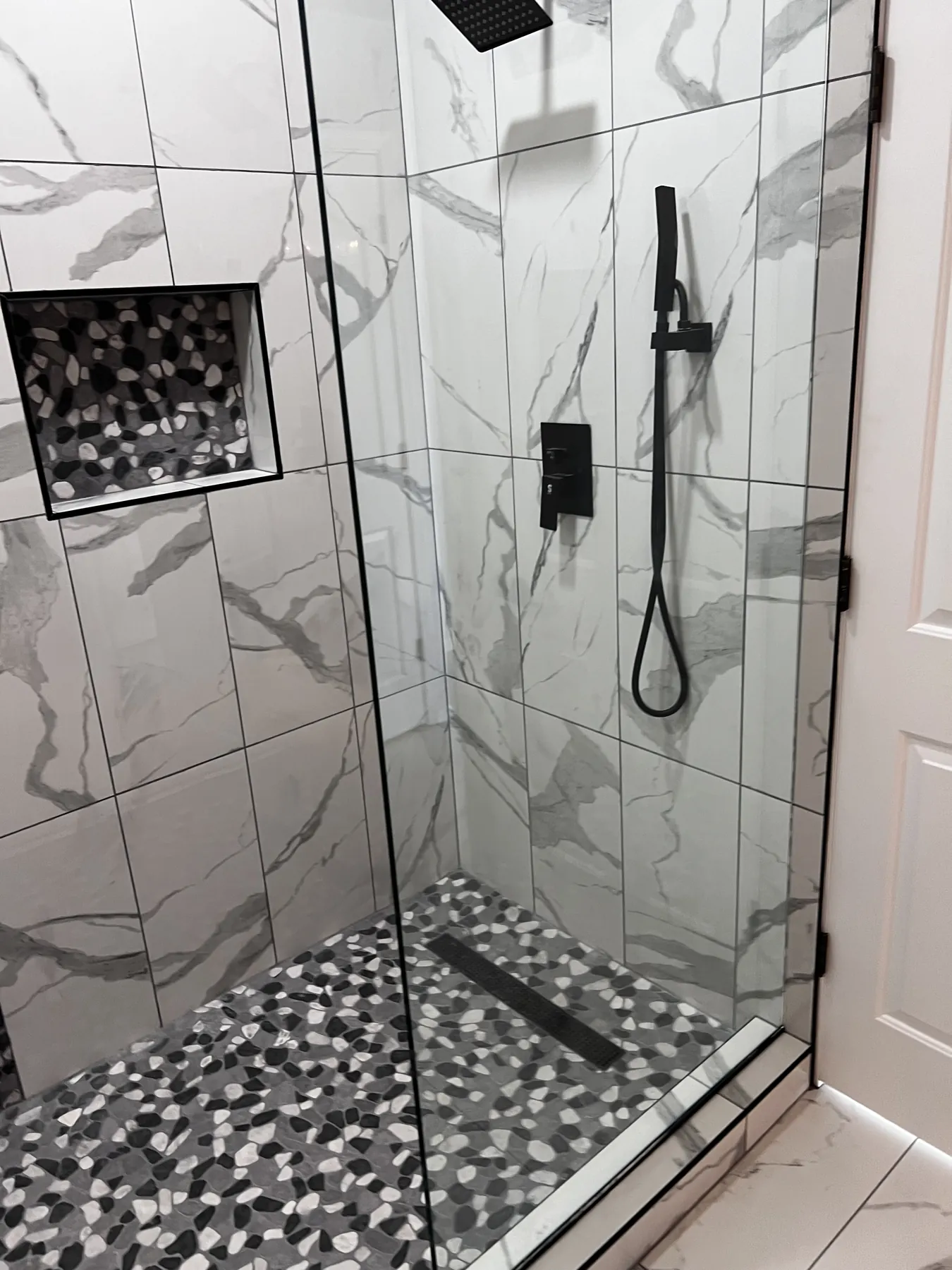 Custom shower glass and mosaic tile floor detail