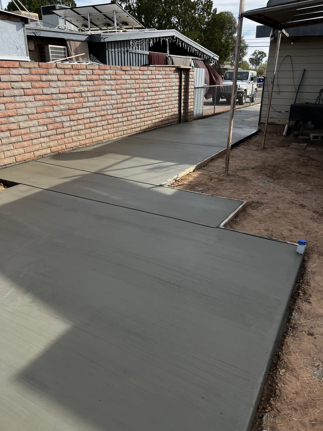 Completed concrete walkway alongside a residence