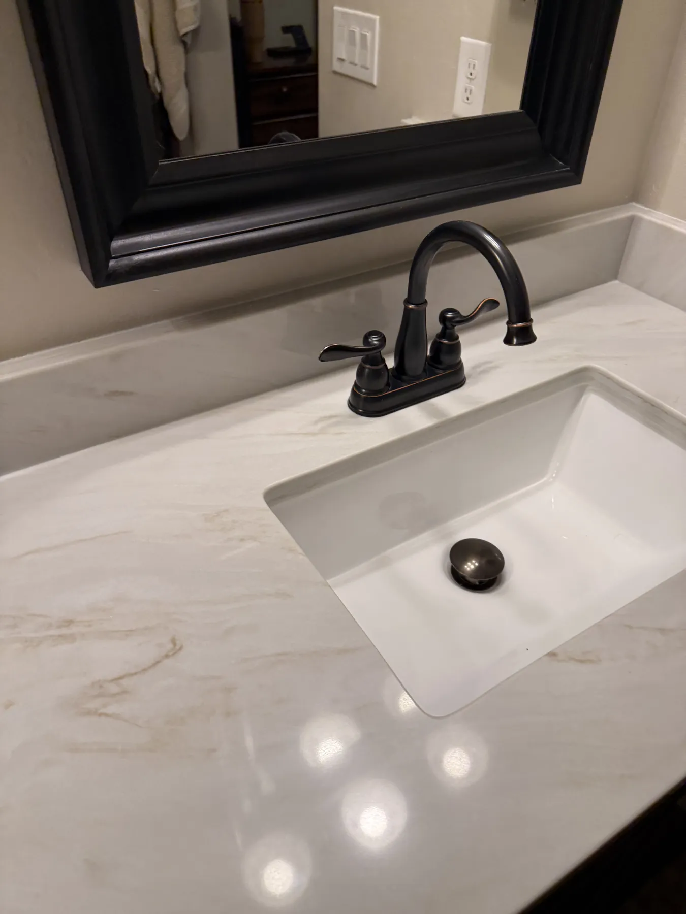 Dark vanity with expressive stone countertop