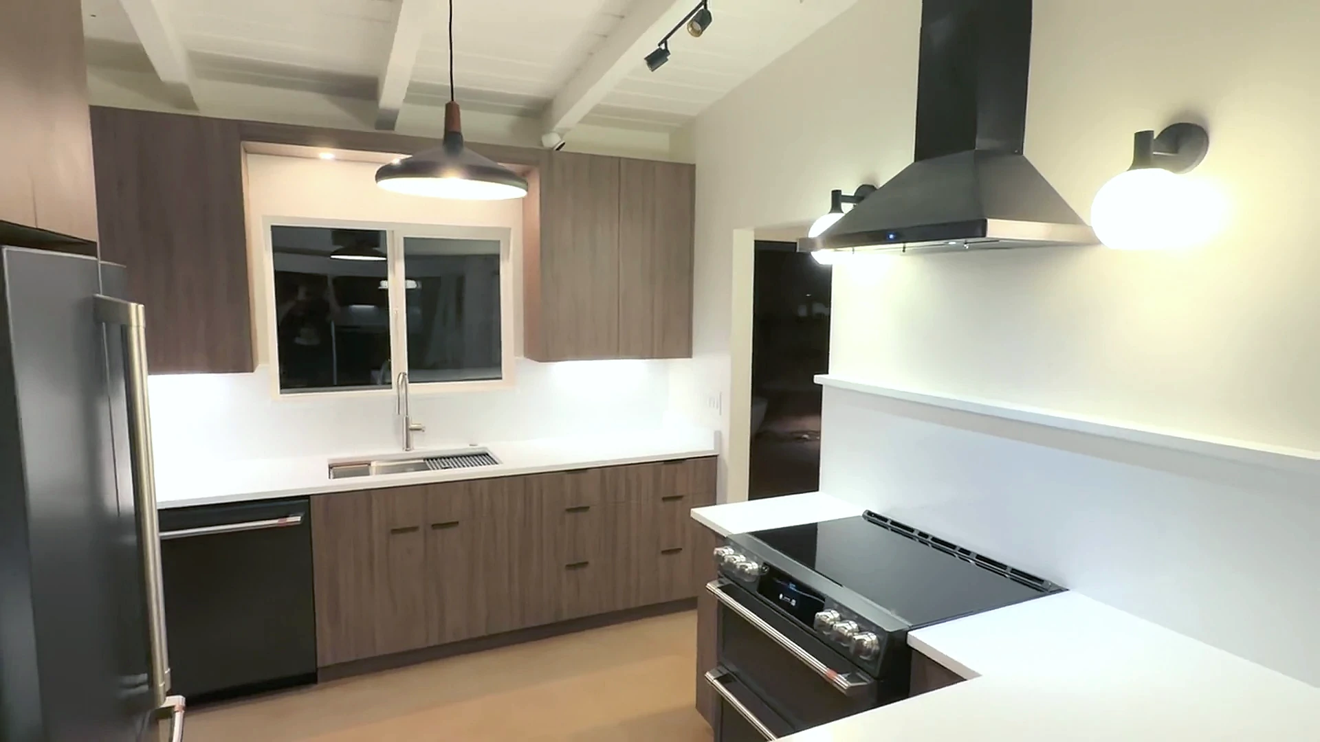Walnut cabinetry framing the sink wall and coordinated range hood
