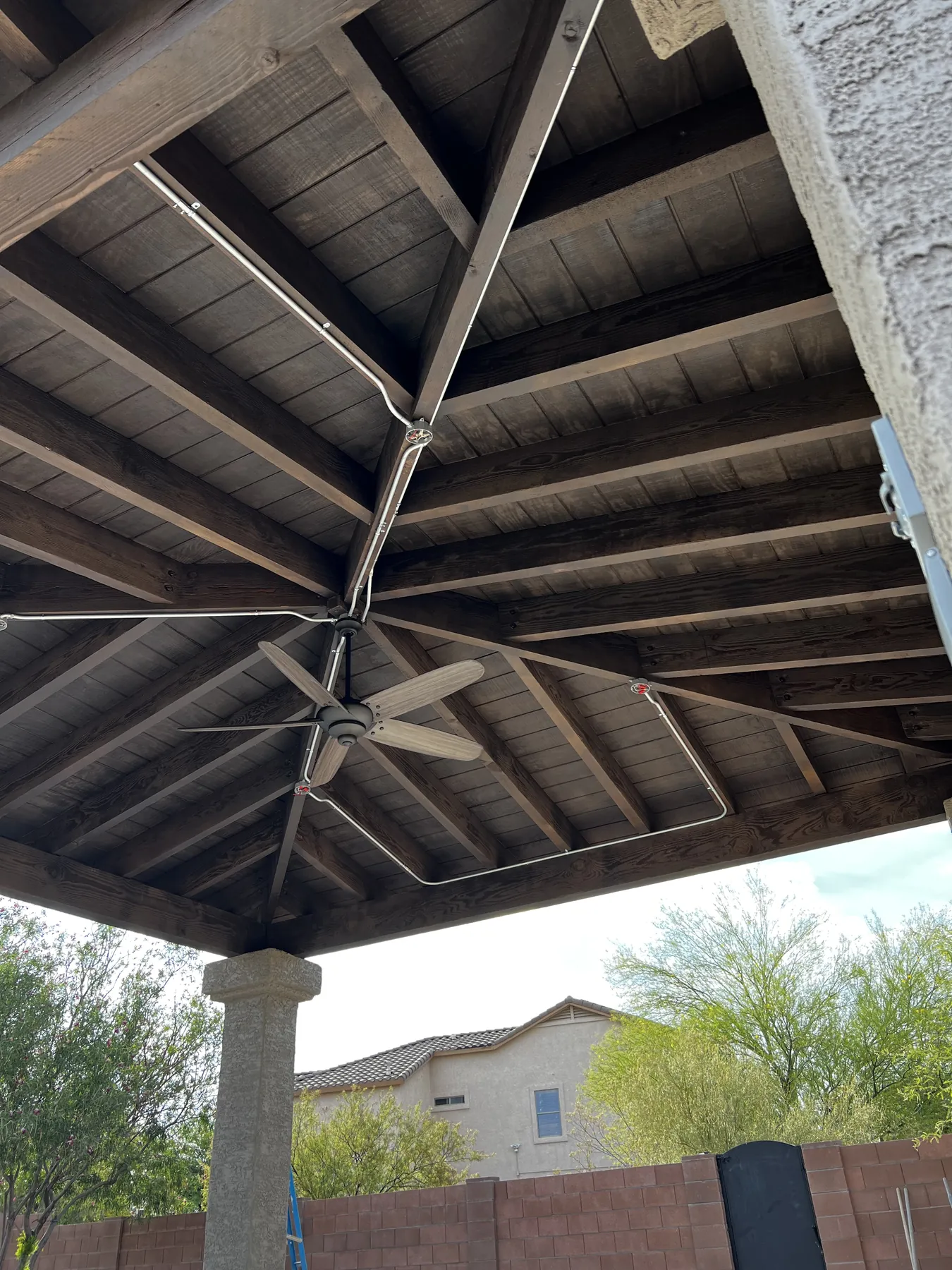 Finished ramada ceiling showing exposed wood structure and an integrated fan