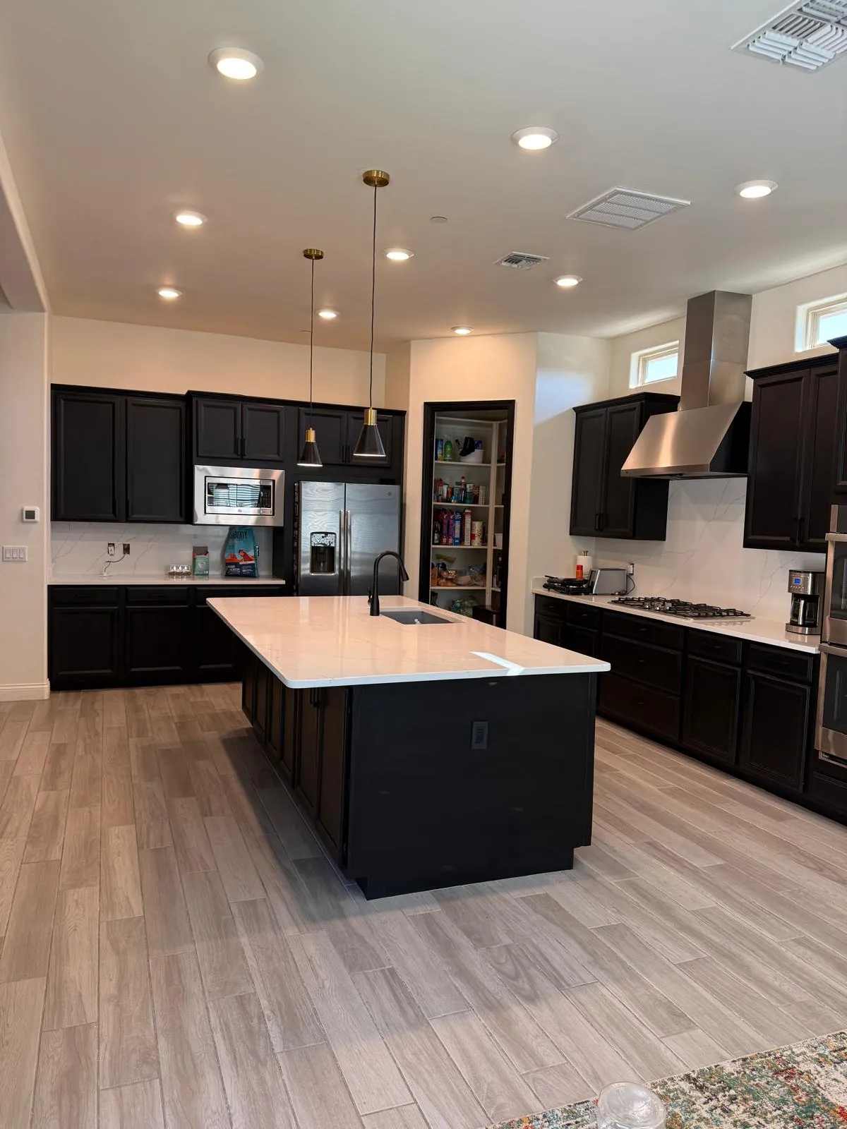 Completed kitchen with dark cabinetry, white countertops and island