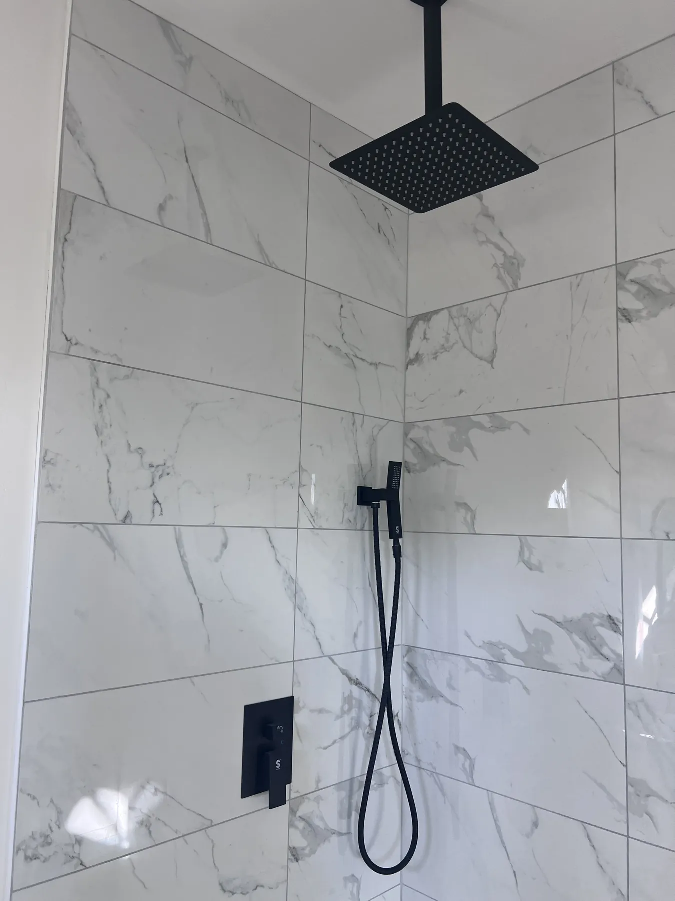 Marble-look tile installed in a custom shower