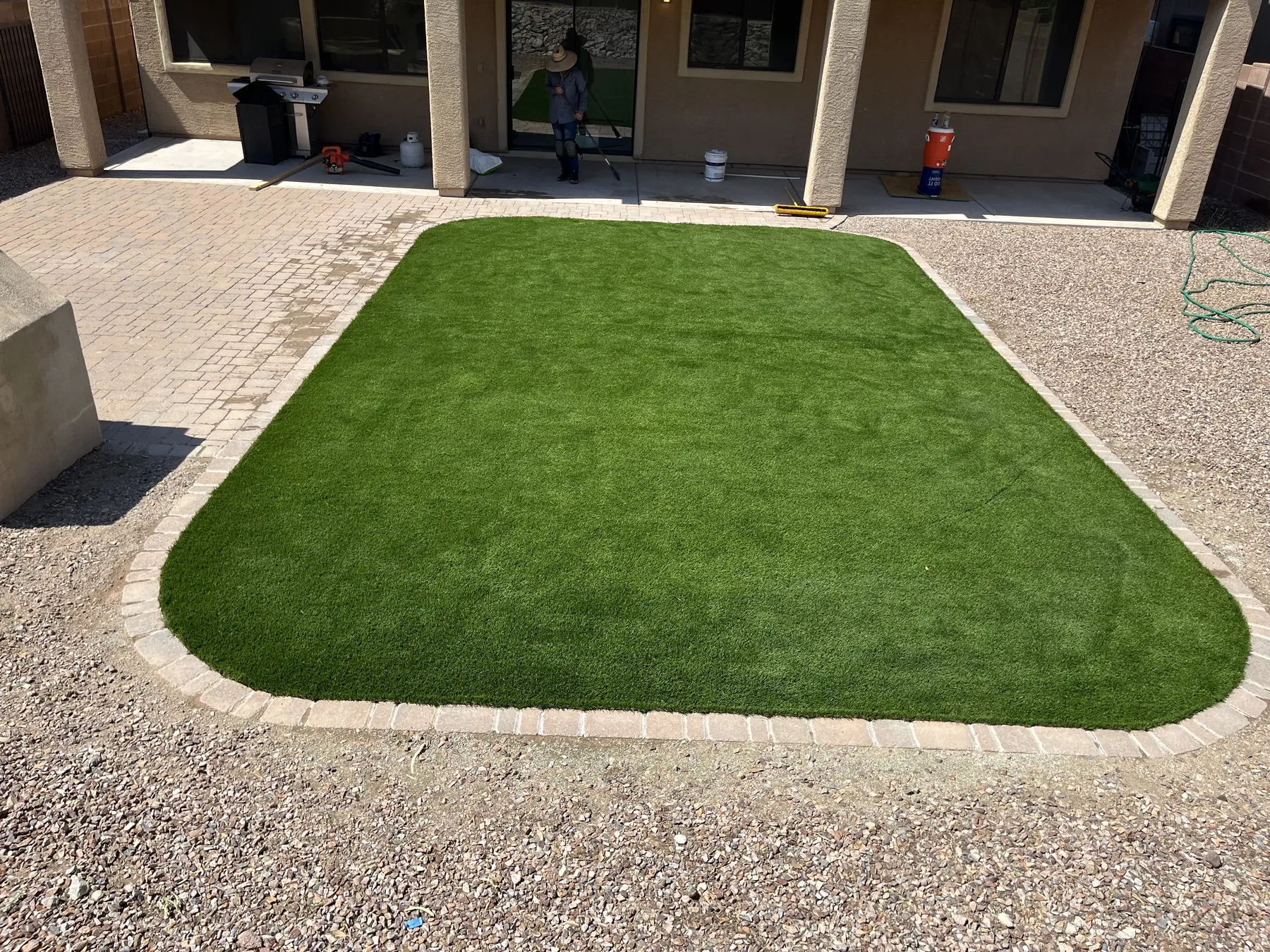 Completed artificial turf courtyard framed with pavers