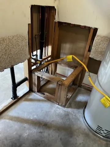 Wall cavity opened beside a water heater during mitigation access